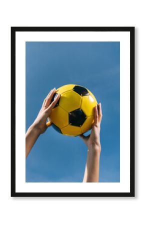 Human's hands holding a soccer ball