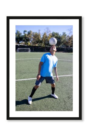 Hispanic soccer play balancing a ball on his head while practiving and playing the game. 