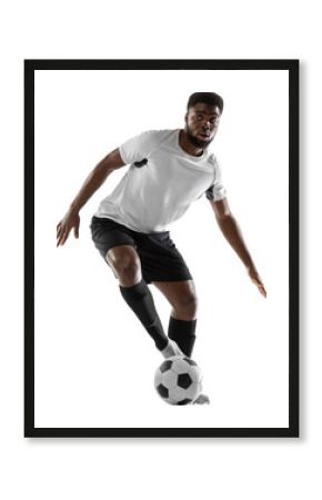 Dribbling the ball. Young African man, male football soccer player training isolated on transparent background. Concept of sport, competition, tournament, hobby, active lifestyle