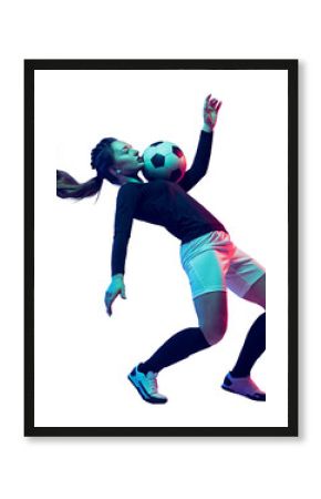 Young athletic girl, soccer player in uniform in motion, training, playing football, kicking ball with chest isolated on transparent background. Concept of sport, competition, tournament, game