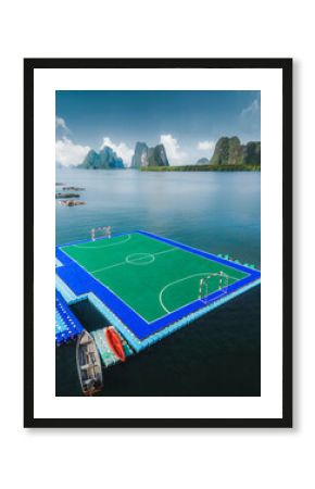 Aerial view of floating soccer field surrounded by mountains and boats, Mueang Phang Nga, Thailand.