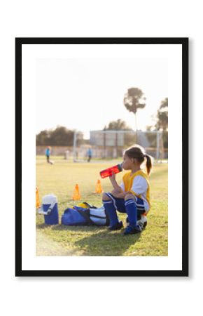 Girl drinking water on soccer field