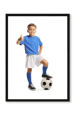 Cute little boy in a sports jersey stepping on a soccer ball and gesturing thumbs up