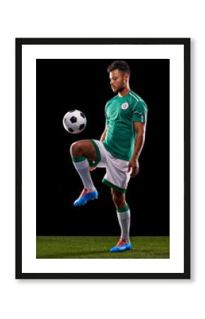 Perfect control. Full length studio shot of a handsome young soccer player isolated on black.