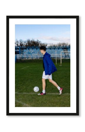 A young guy trains on the soccer field