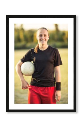 Young female soccer player posing with soccer ball