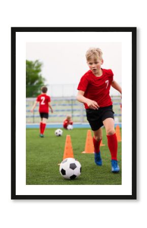 Soccer Boy on Training with Ball and Soccer Cones. Dribbling Drill. Soccer Kids Dribble Training. Youth Soccer Club Practice Session. Boys in Sports Team in Red Soccer Uniforms