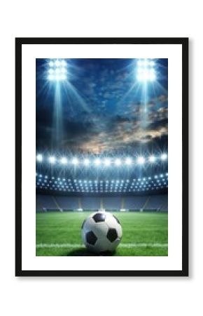 Bright stadium lights illuminate soccer ball on field at night