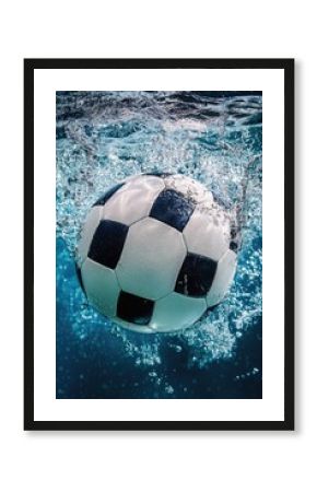 A soccer ball floats on the surface of calm water
