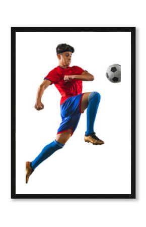Photo in motion of young soccer football player kicking ball with knee in jump. Man training in uniform against transparent background. Concept of match, championship, action, team sport game, energy.