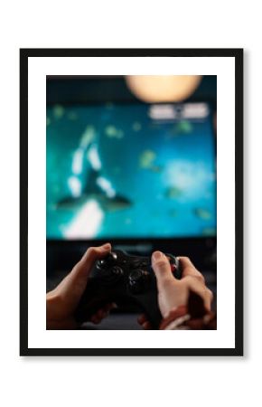 Close up of woman holding joystick and playing video games on computer. Gamer using controller to play online digital games in front of monitor. Person with modern gaming equipment