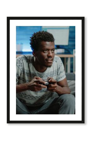 Young adult losing at video games on TV console with joystick. Frustrated person playing online game with controller on television for entertainment and free time activity. Man gaming