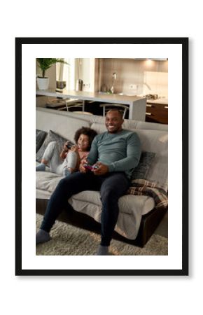 son with open mouth and father playing video game