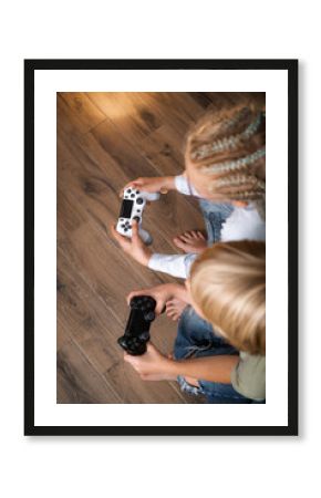 boy and girl playing video game console using joystick or controller while sitting at home, Two children small caucasian brother and sister happy children siblings, real people family leisure concept.