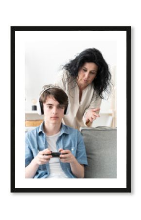 Mother scolding son while he is gaming