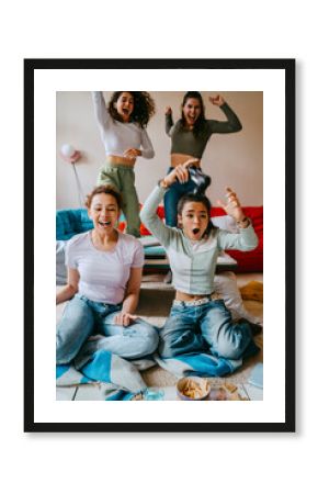 Cheerful female friends having fun playing video game at home