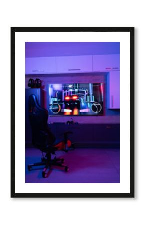 Gaming chair for video games in neon room with video streaming on screen, copy space