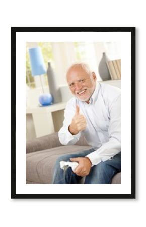 Older man giving thumb up with computer game