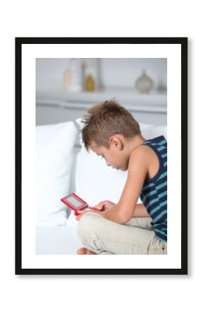 Little boy playing video games on sofa