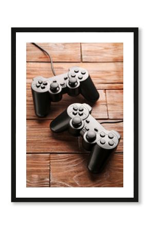 Black joysticks on a brown wooden table