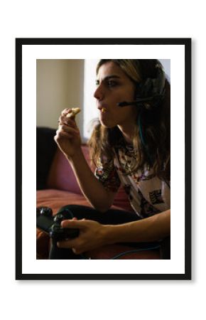 Teen with headset playing video games and eating cookies