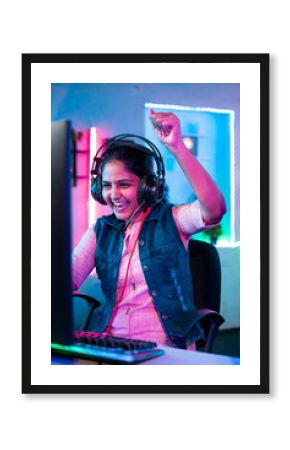 vertuical shot of happy gamer celebrating win or victory while playing online video game tournament on computer at home - concept of success, championship and live streaming.