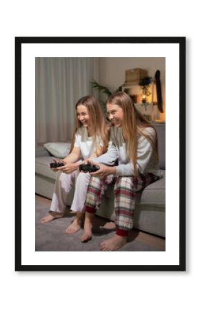 Sisters wearing pajamas playing video game