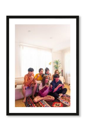 Group of Young Asian man and woman playing video games together in living room at home. Happy people friends enjoy and fun indoor activity lifestyle spending time together on holiday vacation.