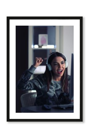Emotional young woman playing computer game at home