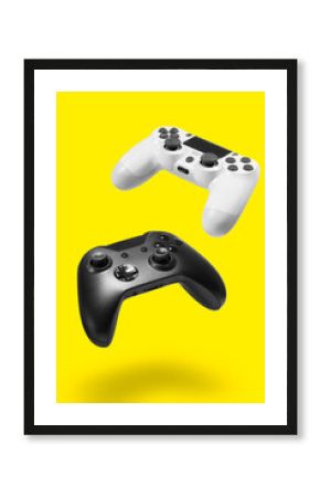 White and black game controllers on yellow background