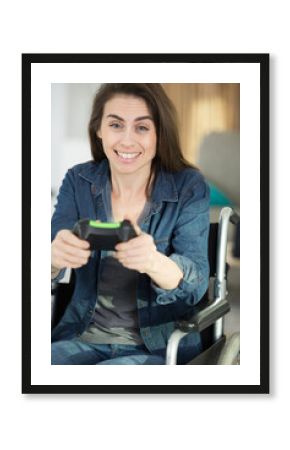 young woman in wheelchair playing computer game at home