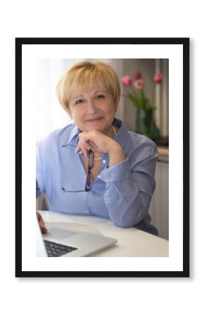 Senior Smiling Woman  working on laptop at home .  online teacher  concept