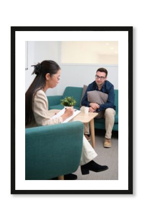 Professional psychologist carefully making notes during a treatment interview.