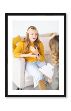 Joyful patient teenager girl on consultation with psychologist. Blurred foreground.