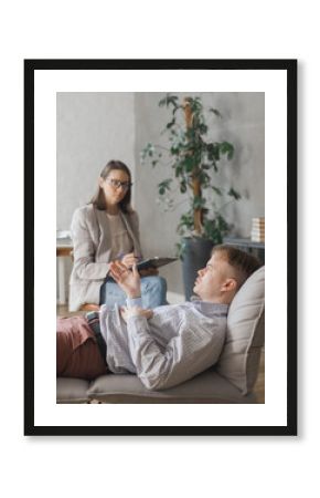 female psychologist conducts psychotherapy session for man. patient in clinic's office on couch talks about his worries and stresses. diagnosis of depression, anxiety disorder. taking care of mental