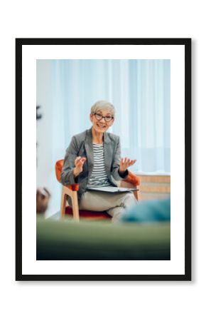 Senior woman psychiatrist talking with her patients during therapy session