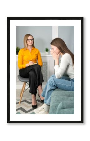 Counseling on depression, apathy. Young woman tells a psychologist about her life, she is sad, she put her hands to her face. Focus on the patient. Vertical photo