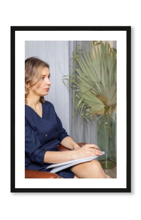 Portrait of a successful female psychologist in her office, notebook in hand