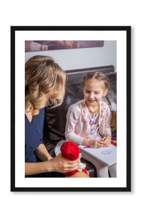 The girl psychologist plays a puppet character game with the child