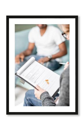 Psychologist filling documents during a psychological session with african man in the office