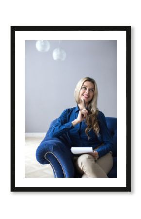 Young beautiful woman sitting in armchair indoors.