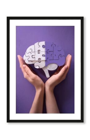 Hands holding brain with puzzle paper cutout, autism, demential, Epilepsy and alzheimer awareness, seizure disorder, world mental health day concept 