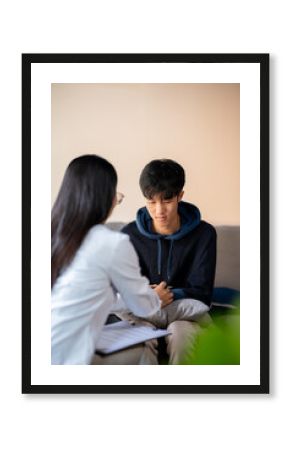 A sad, depressed young Asian man receives mental health advice from a psychologist at the clinic.