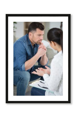 counselor taking notes while analyzing young man