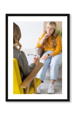 Teenage girl on consultation with psychotherapist. Close-up of hand with pen.