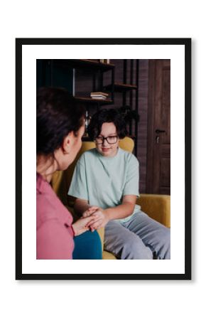 a Caucasian teenage girl is sitting in a chair in a room at a reception with a female psychologist