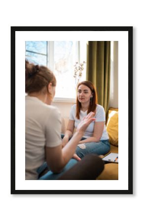 Young woman psychology therapist on yellow sofa with patient.