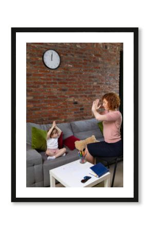 Young woman and little girl, doctor and kid communicate at psychologist office. Preschool girl feeling at ease in therapist's office. Concept of support, help, childhood