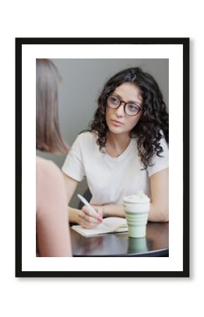 Spanish woman psychologist or business coach conducts a session with a client and takes notes in a notebook. formation, change of activity. Mental health and psychological health support