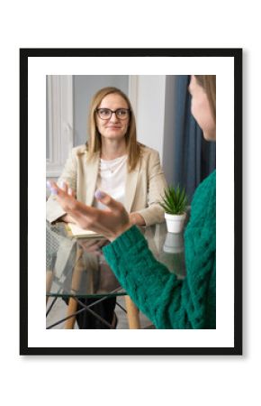 Psychological counseling. Close-up of a psychologist with a patient sitting at a table in the office. Concept of psychological health, psychotherapy. Vertical photo